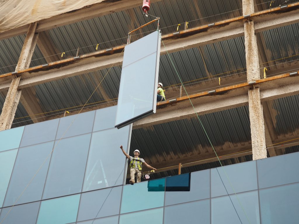 A construction worker installing one of the glass and steel panels at Five City Center in Allentown.